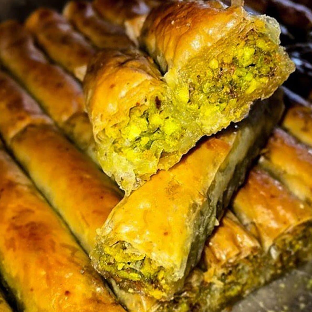Baklawa roulés et dorés, ouverts sur une farce de pistache